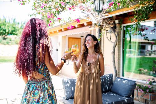 two women with purple hair holding glasses of wine at Limora' Tenuta Millaci in Mazzarino