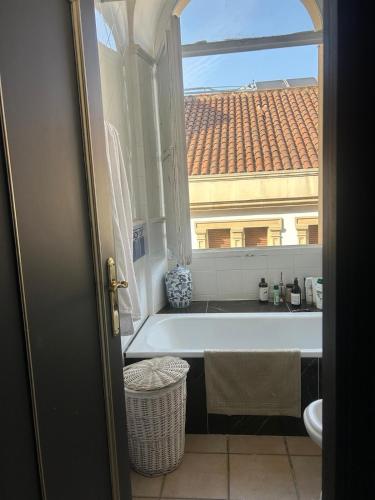a bathroom with a bath tub and a window at La Casa de Claudio Marcelo in Córdoba