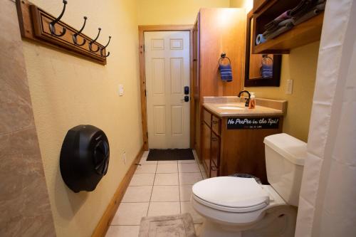 a small bathroom with a toilet and a sink at Tipis on the Guadalupe in New Braunfels