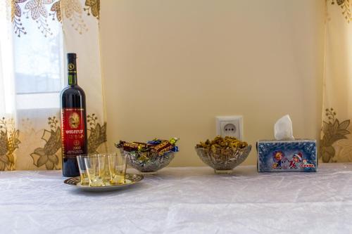 a bottle of wine and two bowls of food on a table at Lusya B&B in Yeghegnadzor