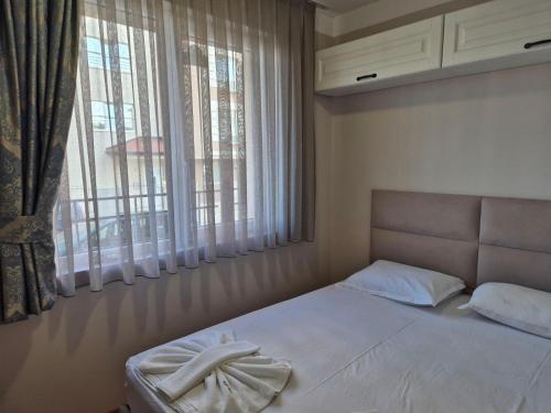 a bedroom with a bed and a large window at Marea Garden, Ravda - Studio with Pool by Flat Mаnager in Ravda