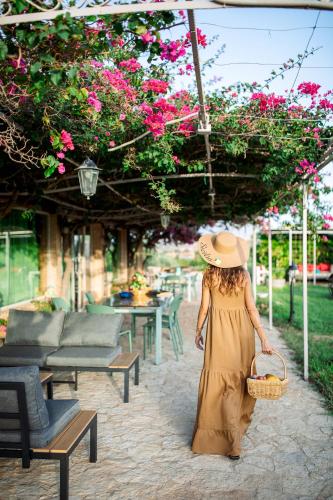 a woman in a straw hat carrying a basket at Limora' Tenuta Millaci in Mazzarino