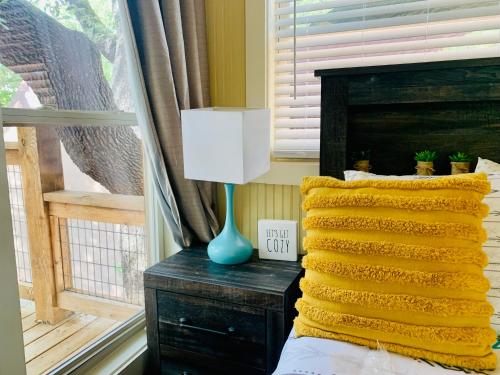 a bedroom with a bed with a lamp and a window at Tipis on the Guadalupe in New Braunfels