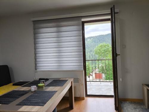 a room with a window with a view of a balcony at Planinska Kuca "KABLAR" Jahorina in Ćetinište