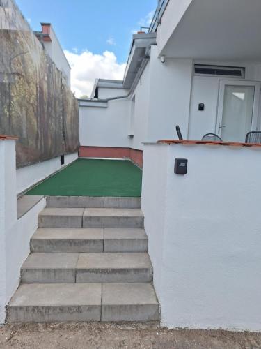 a stairway leading up to a house with a green floor at Appartement Confidence, Monteurwohnung in Bürstadt