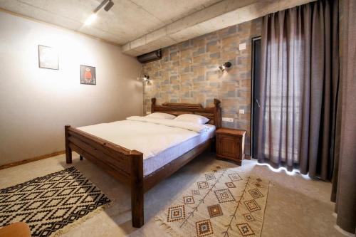 a bedroom with a bed and a brick wall at Kera Ethno Hotel in Gvishtibi