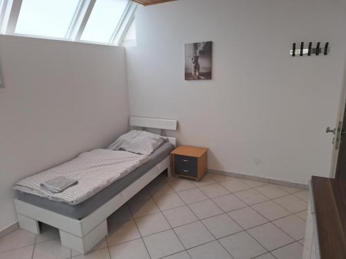 a small bed in a room with a window at Appartement Confidence, Monteurwohnung in Bürstadt