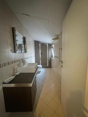 Un baño con lavabo, inodoro y espejo. en Casa MiLo, en Foggia