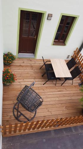a wooden deck with a table and chairs on it at Authentic Apartment hotel in Český Krumlov