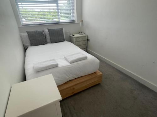 a bedroom with a bed with white sheets and a window at Blue House in Stone Grove