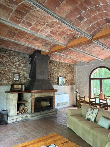 a living room with a fireplace and a couch at Casanova de Baix in Ripoll