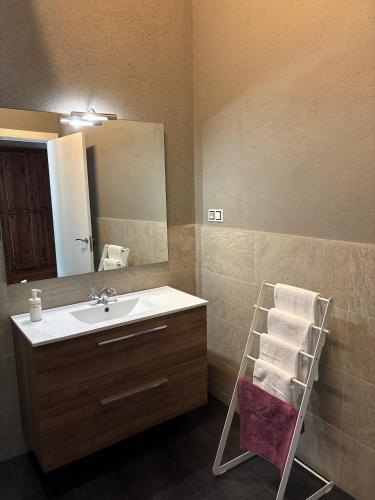 a bathroom with a sink and a mirror and towels at Casanova de Baix in Ripoll