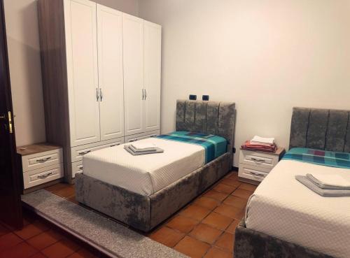 a bedroom with two twin beds and white cabinets at KapaCasa in Rome