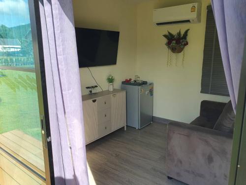 a living room with a flat screen tv on the wall at Nordika Hill in Pak Chong