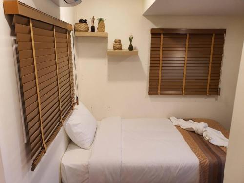 a bedroom with a white bed and a window at Nordika Hill in Pak Chong