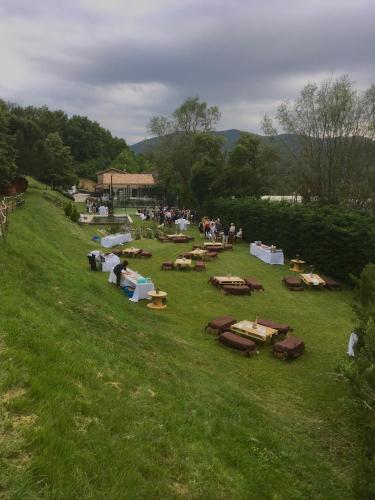 a group of tables in a field with a crowd of people at Casanova de Baix in Ripoll