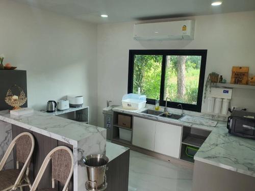 a kitchen with marble counter tops and a window at Nordika Hill in Pak Chong