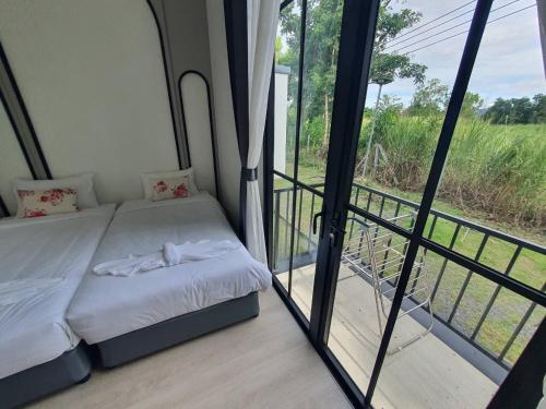 a small bed in a room with a window at Nordika Hill in Pak Chong