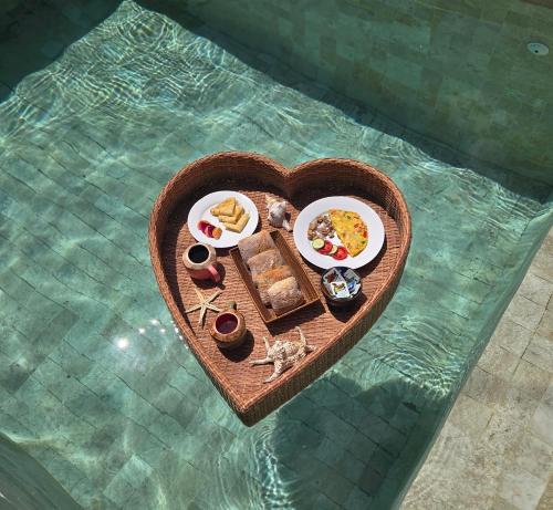 ein herzförmiges Tablett mit Lebensmitteln in Herzform in der Unterkunft Anna's Beach House - luxury private beachfront villa in Gili Air