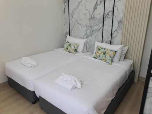 two beds in a room with white sheets and pillows at Nordika Hill in Pak Chong