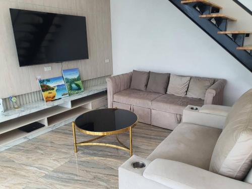 a living room with a couch and a tv at Nordika Hill in Pak Chong