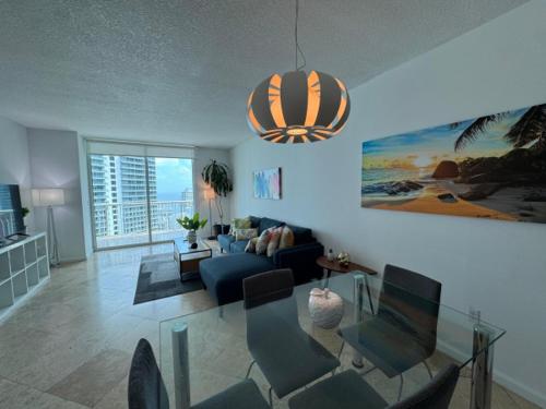 マイアミにあるAmazing apartment in the Heart of Brickellの青いソファとガラスのテーブルのあるリビングルーム