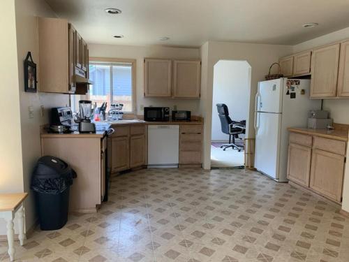 a kitchen with wooden cabinets and a white refrigerator at Cedar River Home Away From Home in Renton