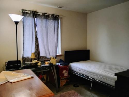 a room with a bed and a desk and a window at Cedar River Home Away From Home in Renton