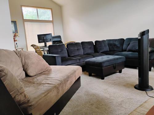 a living room with a black couch and a table at Cedar River Home Away From Home in Renton