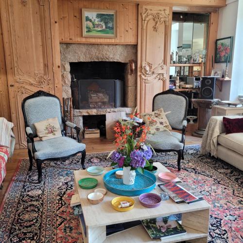 a living room with a coffee table and a fireplace at Chambres d'Hôtes Maison de Charme à Trégastel in Trégastel