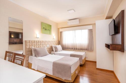 モジ・ダス・クルーゼスにあるHotel Marborのベッド2台とテレビがあるホテルの部屋
