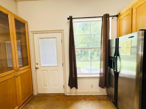 a kitchen with a refrigerator and a window at Chateau 10 in Hammond