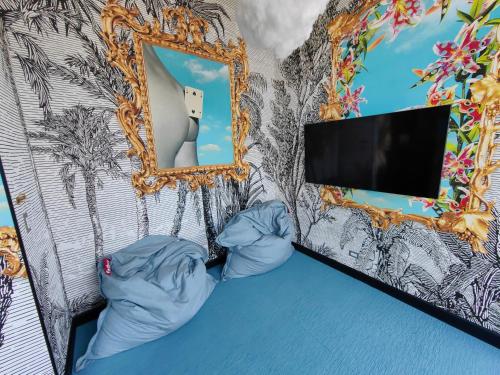 a room with a bed with a mirror and a tv at 2811 SECRT Sabana Hermoso Estudio in San José