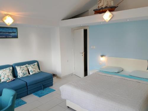 una camera da letto con un letto e un divano blu di Beautiful view a Kotor (Cattaro)
