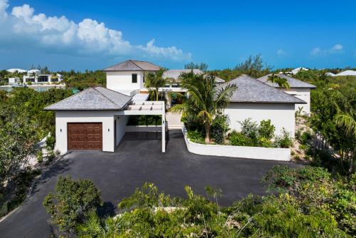 an aerial view of a house with a driveway at The essence of fun under a tropical sun villa in Leeward