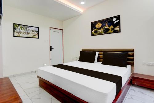 a bedroom with a large bed and two pictures on the wall at Hotel O Railway in Vadodara