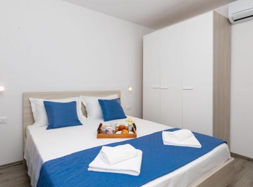 a bedroom with a large bed with blue and white pillows at Apartment Kurte in Nerežišća