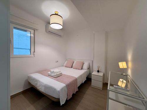 a white bedroom with a bed and a window at 3 Double Beds - Great Area, Perfect for Families in Seville