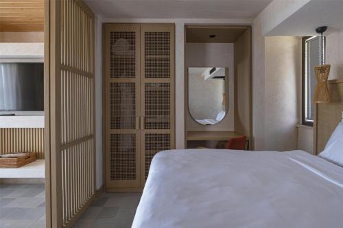 a bedroom with a white bed and a mirror at Radisson Blu Hotel, Kas in Kas