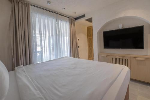 a bedroom with a white bed and a large window at Radisson Blu Hotel, Kas in Kas