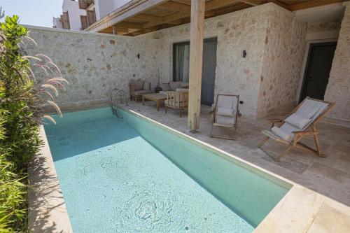a swimming pool with two chairs and a table at Radisson Blu Hotel, Kas in Kas