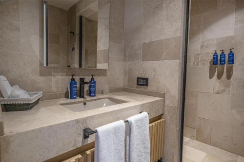 a bathroom with a sink and a mirror and towels at Radisson Blu Hotel, Kas in Kas