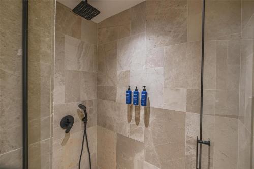a shower with three blue bottles on the wall at Radisson Blu Hotel, Kas in Kas