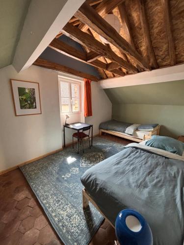 une chambre avec un lit et une table dans une pièce dans l'établissement YXIE - Manoir des Arts, à Villeblevin