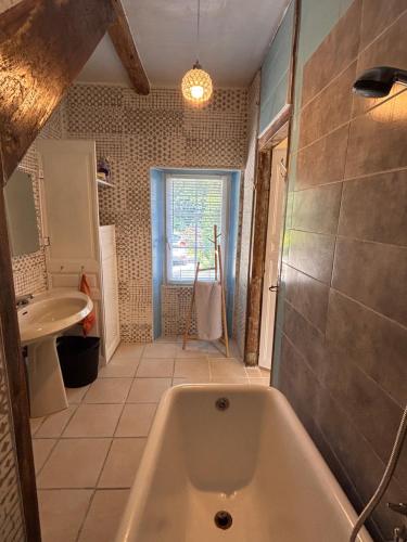 une salle de bain avec une baignoire et un lavabo dans l'établissement YXIE - Manoir des Arts, à Villeblevin