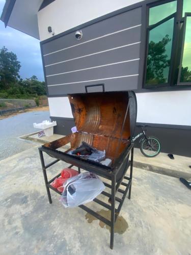 a large wooden instrument sitting in front of a building at Permai Homestay in Kampong Burok