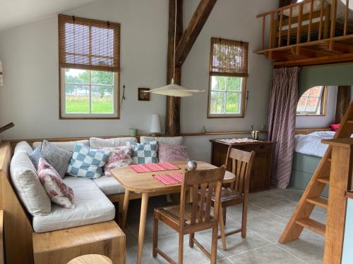 a living room with a couch and a table at Romantische Bedstay de Volle Hand in Terwolde