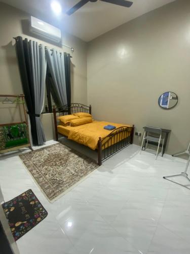a bedroom with a bed and a table and a chair at Permai Homestay in Kampong Burok