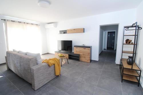 a living room with a couch and a television at Fly in Apartment in Čilipi