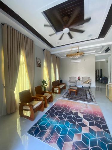 a living room with a colorful rug on the floor at Permai Homestay in Kampong Burok